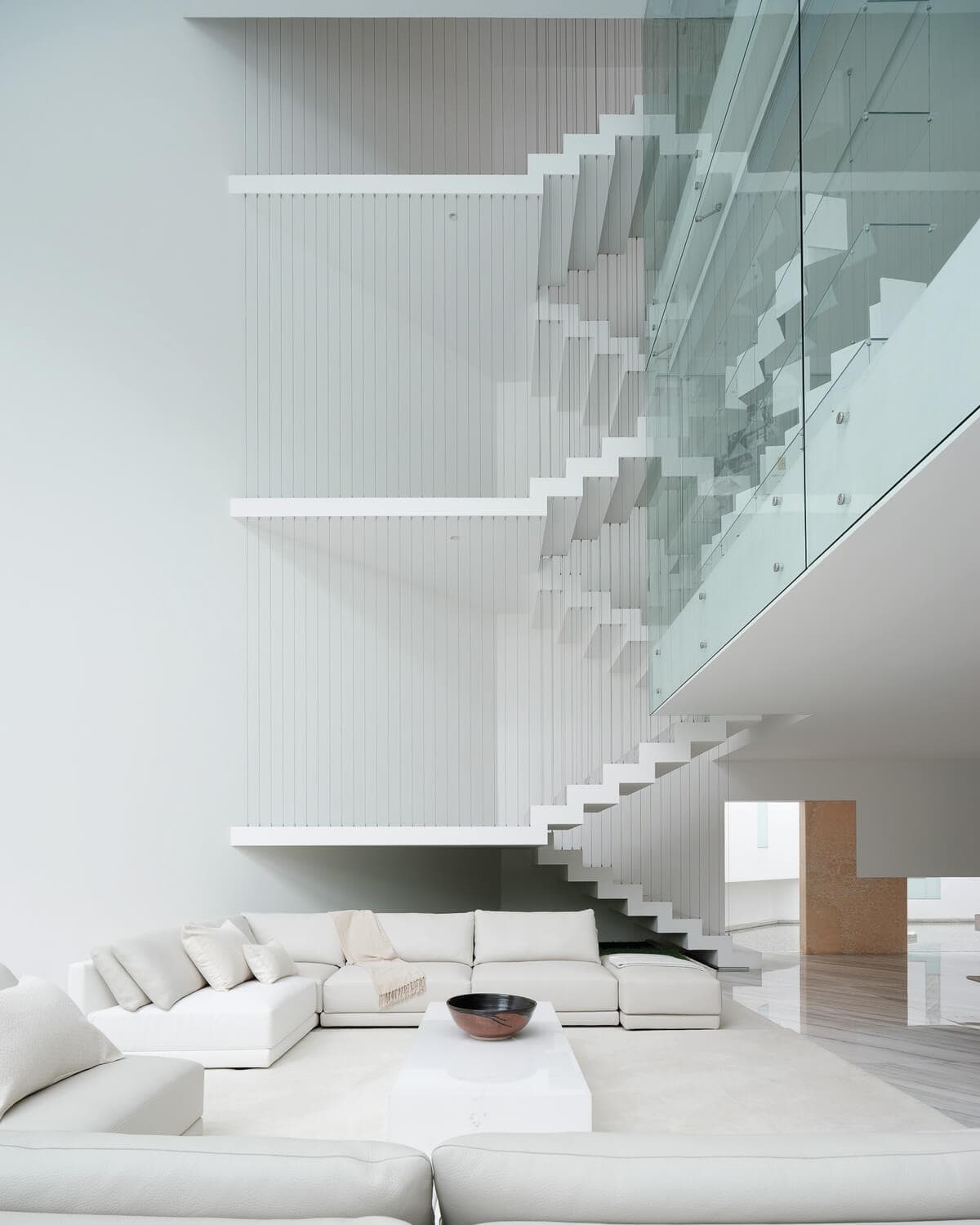 Interior de residencia privada en Ciudad de México con sala, escalera abierta y ventanales altos.